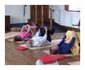 picture of people lying on yoga mats hugging their knees
